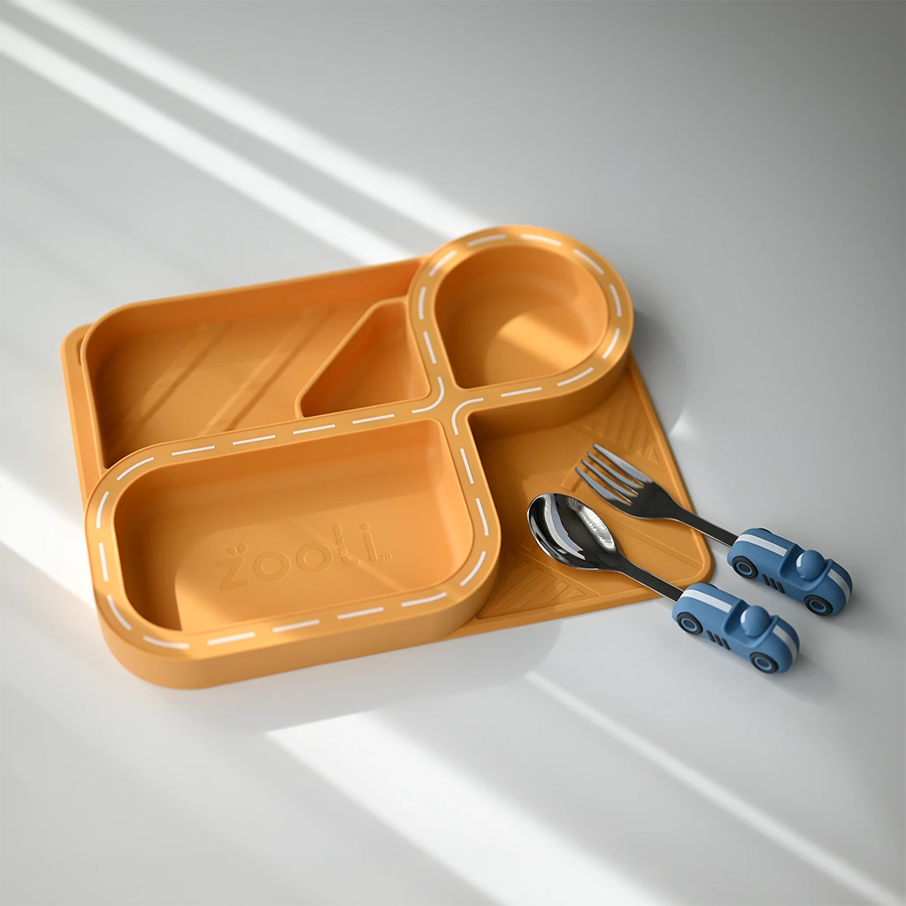 A vibrant yellow silicone racetrack plate set designed for kids, shaped with divided sections for organized meals. Paired with a car-themed spoon and fork in blue, this playful dinnerware set is perfect for toddlers and young children